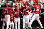Arkansas catcher John Clay Reeves (14) is congratulated by Coach Dave Van Horn (middle) and teammates Saturday after scoring a run in the third inning of the Razorbacks’ 7-6 victory over South Carolina at Baum Stadium in Fayetteville. 