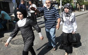 A Lebanese family leaves sectarian fighting Tuesday in the port city of Tripoli. 