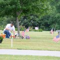James Collins lays down flowers on the grave of Jesse Samek on Monday before the start of the 24th a...
