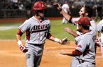 Arkansas freshman right fielder Brian Anderson (left) is congratulated by teammates after scoring the lone run in the Razorbacks’ 1-0, 10-inning victory over Baylor on Monday in Waco, Texas. Despite finishing 9-9 to end conference play in the regular season and losing their only two games in the SEC Tournament, the Razorbacks have turned things around in the NCAA Tournament and will make their seventh trip to the College World Series in Omaha, Neb. 