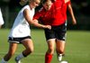 Shelby Frazier of Mountain Home (left) and Julie Whitlow of Rogers Heritage battle for the ball during the West’s 2-1 victory over the East on Tuesday in the Arkansas High Cchool Coaches Association All-Star girls soccer game. 