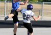 Zach Jones, Mounties wide receiver, left, goes for a pass in the end zone during an NWA Passing League game at Rogers Mounties Stadium in Rogers on Monday.