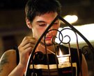 Terry Willey, 24, lights a candle for the families and all involved in the theater shootings during 
