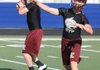 Drew Harris, right, and Dakota Riggin, Lincoln quarterback candidates, warm up before an NWA Passing League 7-on-7 game at Rogers Mounties Stadium. The two are vying to lead the Wolves this season.