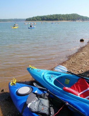 Kayaks fan out on Beaver Lake for a trip around Bear Island.