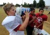 Mason McConnell, 12, left, and Caleb Seawood, 11, drink water as Marcus Murray, 11, rests during a break at the fifth- and sixth-grade Kiwanis Kids red football team practice Thursday at the Tyson Sports Complex in Springdale. 
