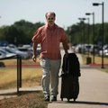 John Vettraino of Detroit pulls his luggage toward the terminal at Northwest Arkansas Regional Airpo...