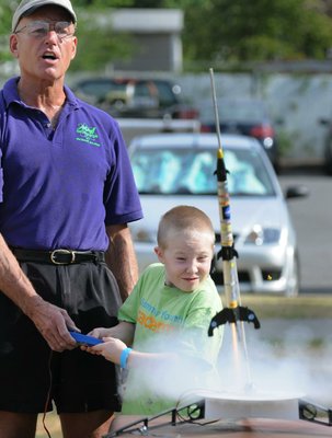 
                               
                                  Photo by Spencer Tirey&mdash;
                               
                           
                           Stephen Cox with Mad Science of Arkansas finishes counting down as Kevin Cain pushes the button and watches the Estes Rockets he made take off.