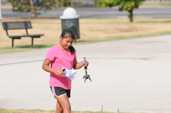 
                           Sandra Gomez picks up her Estes Rockets she made after launching it.