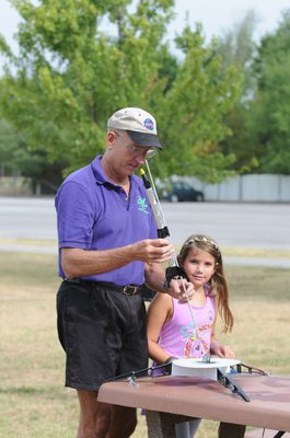 
                           Stephen Cox with Mad Science of Arkansas loads Ally Elmore's rocket on a launch pad at the Summer Youth Academy Camp at the Jones Center.