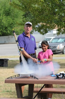 
                           Stephen Cox with Mad Science of Arkansas finishes counting down as Sandra Gomez pushes the button.