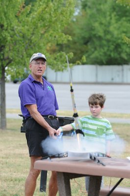 
                           Stephen Cox with Mad Science of Arkansas finishes counting down as Adam Stanton pushes the button and watches the Estes Rockets he made take off.