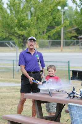 
                           Stephen Cox with Mad Science of Arkansas finishes counting down as a student pushes the button and watches the Estes Rockets he made take off.
