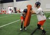 Wilder Blockburger, left, slams into pads held by Utah Julius while running through drills Friday in the indoor practice facility at Rogers Heritage High School. The War Eagles’ first game is slated for Aug. 21 at Russellville. 