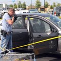 Michael Hendrix, a Springdale police detective, examines a Ford Focus on Friday, Aug. 3, in the Walm...