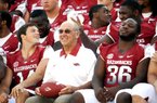 Arkansas offensive lineman Jason Peacock (upper right) inserts some fun and games into media day at Arkansas when he puts “bunny ears” behind Coach John L. Smith during a team photo Saturday. Punter Dylan Breeding (14) watches Peacock while fullback Kiero Small (36) focuses his attention elsewhere.