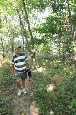Stanfill walks along a wooded part of the trail.