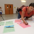 Hester LeMire signs up her son, Jonah, for a physical education class Aug. 2 during an event sponsor...