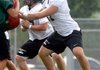 Trevor Foster, right, a Bentonville offensive lineman, works through drills Wednesday during practice at Tiger Stadium in Bentonville. 