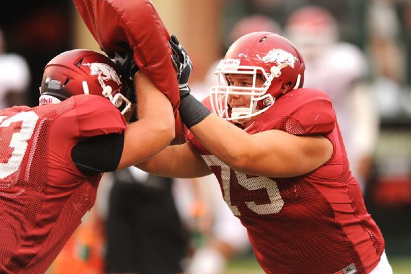 Arkansas sophomore offensive lineman Luke Charpentier (right) works through a drill before Saturday’s scrimmage at Razorback Stadium in Fayetteville. 