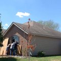 Men board up a window Monday at the house where a woman was killed Sunday.
