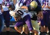 Fayetteville’s Jordan Dennis is pulled down by Pulaski Academy’s Jonathan Williamson after catching a pass Monday in a scrimmage at Joe B. Hatcher Stadium in Little Rock.