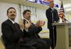 Custom Aircraft Cabinets Inc. owners Mike Gueringer (left) and Paul Reesnes (center) applaud as Gov. Mike Beebe speaks Friday in Sherwood during a news conference to announce plans for 150 new jobs at the company.