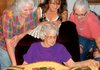 Granddaughters Diane Pennington, left, and Machelle Lamb, right, along with family friend Karla Taylor, gather around Vola Edgmon to look at the quilt they made to surprise her.