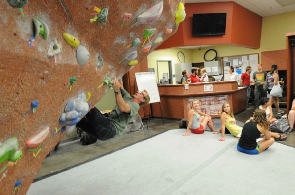 
                           Students waiting to depart on a kayak trip watch Connor Wilson test his skills on the bouldering wall.