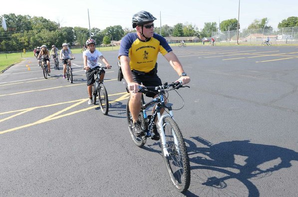 Cpl. Will Gardner with the Bentonville Police Department, leads students on a ride that teaches the fundamentals of braking and shifting. Gardner is the school resources officer for both junior high schools in Bentonville.