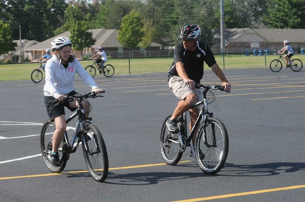 Lincoln Junior High teacher Josh Schluterman helps a student with her bike skills.