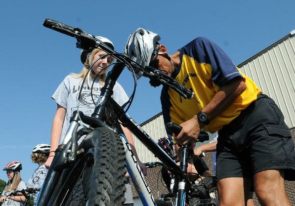Falcon adjusts a bike seat.