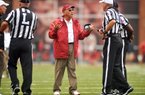 Arkansas Coach John L. Smith speaks with referees during Saturday’s game at Reynolds Razorback Stadium in Fayetteville. Smith said he took responsibility for replacing sophomore deep snapper Will D’Appollonio with junior Will Coleman early in the game. 