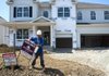 A construction worker places a sign in front of a new home in the Fox Glen subdivision of Pickerington, Ohio, in August. Builders this month reported the best sales level since July 2006. 