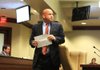 Lottery Director Bishop Woosley leaves a legislative oversight committee meeting Tuesday after speaking to lawmakers. 
