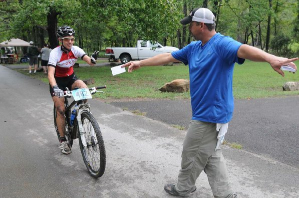 Phil Penny, right, with the Ozark Off Road Cyclists checks in a racer at the finish line.