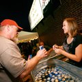 Tamra Kesner, right, of Springdale, serves a beer to Mark Nicholson of Cabot on Thursday at The Rogu...