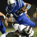 STAFF PHOTO MARC F. HENNING -- Rogers quarterback Nick Wary leaps over a Springdale defender on a ca...