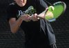 Jordan Sheppard of Bentonville volleys the ball back to his opponent Monday at Memorial Park in Bentonville during a match against Rogers High School.