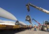 Workers load a wind turbine blade onto a rail car at the port in Corpus Christie, Texas, last month. Work on some U.S. wind industry projects has stalled as investors wait to see whether a federal tax credit for wind power is extended. 