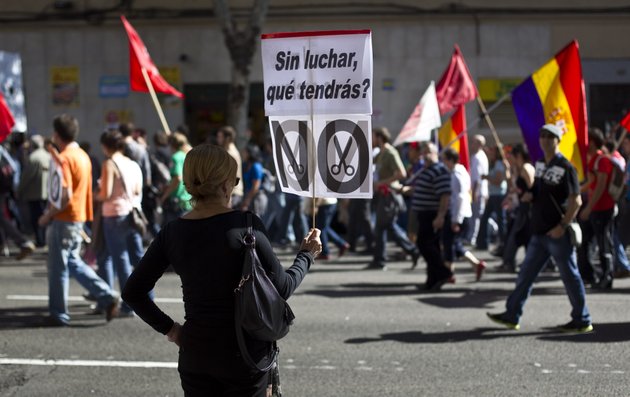 a-woman-holds-a-banner-reading-without-fighting-what-would-you-get-during-a-demonstration-in-madrid-spain-sunday-oct-7-2012-thousands-of-people-called-by-150-organizations-are-marching-in-56-spanish-cities-to-protest-punishing-austerity-cuts-they-say-will-only-increase-unemployment-and-job-insecurity