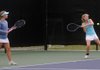 Blair Breazeale, left, waits for her doubles tennis partner Lindsay Will, both from Springdale Har-Ber High School, to volley the ball back to their opponents Tuesday at the Fayetteville Tennis Complex off North Lewis Avenue in Fayetteville. Tuesday was the second and final day of the 7A/6A West Conference Tennis Tournament. Players from Bentonville, Rogers, Rogers Heritage, Springdale Har-Ber, Fayetteville, Bryant and Van Buren competed.
