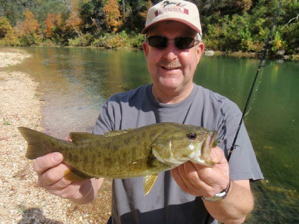 Mark "Hog Ears" Hughes, shows a dandy smallmouth bass he caught with a tube bait. Hughes lives in Anchorage, Alaska and visited Northwest Arkansas last weekend.