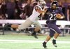 Terrell Tyson, right, a Fayetteville junior receiver, carries the ball as Siloam Springs junior Kevin Munoz reaches to make the tackle Friday during the first half at Harmon Stadium.