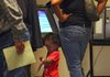 Kailyn Williams, 2, plays with an “I Have Voted” sticker Monday as she waits for her cousin, LaMesha Whitley to vote at the Pulaski County Regional Building. Monday was the first day of early voting. 