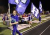 Nick Paschal, a Fayetteville sophomore, runs the flag with fellow cheerleaders Oct. 19 along the sideline after an Bulldogs touchdown against Siloam Springs at Harmon Stadium in Fayetteville. 
