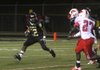Hot Springs running back Chris Pondexter (left) tries to evade two Camden Fairview defenders during the Trojans’ 47-14 loss to the Cardinals on Friday in Hot Springs. 
