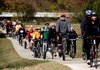 Cyclists make their way south along the newly opened section of the Razorback Greenway on Friday in south Rogers near the “Bridge to the Future.” The group started the ride at the Bentonville square. 