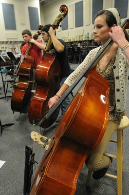 
                           Haley Bowman, right, plays in the bass section with orchestra members Eric Monk, left, and Luke Raihl.