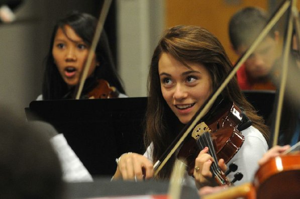 
                           Mary Moreno watches the conductor while practicing with her orchestra-mates, including Gabriella Nepomuceno, left.